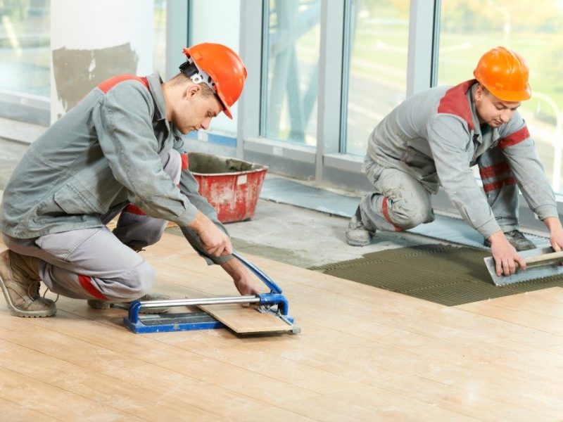 two workers lying tile